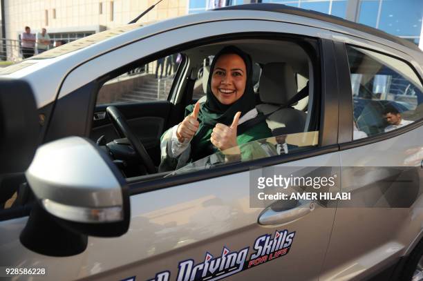 Saudi woman poses for a photo after having a driving lesson in Jeddah on March 7, 2018. Saudi Arabia's historic decision in September 2017 to allow...