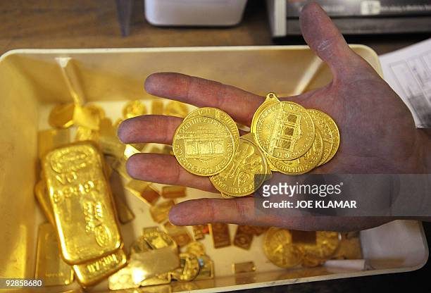 Worker displays scrap gold coins which are to be remelted as they didn't pass the standards at Austrian gold bullion factory Oegussa on October 8,...