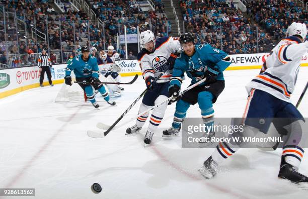 Joe Pavelski of the San Jose Sharks and Anton Slepyshev of the Edmonton Oilers skate after the puck at SAP Center on February 27, 2018 in San Jose,...