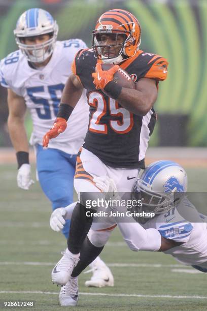 Giovani Bernard of the Cincinnati Bengals runs the football upfield against Akeem Spence of the Detroit Lions during their game at Paul Brown Stadium...