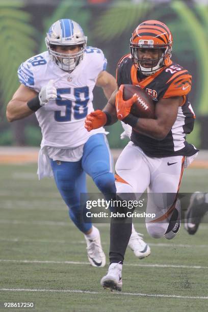 Giovani Bernard of the Cincinnati Bengals runs the football upfield against Paul Worrilow of the Detroit Lions during their game at Paul Brown...