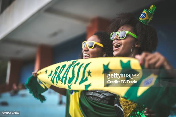 brazilian fan friends celebrating in a soccer game - international soccer event stock pictures, royalty-free photos & images