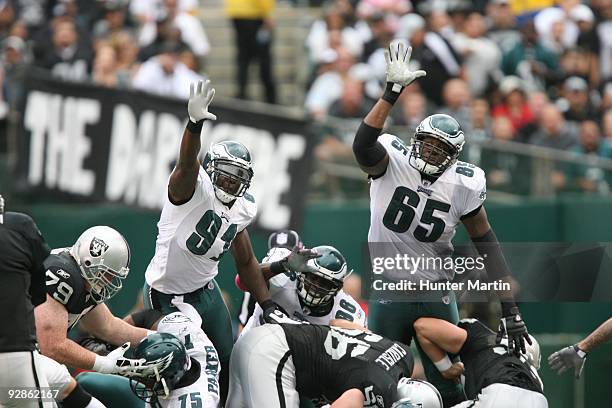 Defensive end Chris Clemons and offensive tackle King Dunlap of the Philadelphia Eagles attempt to block a kick during a game against the Oakland...
