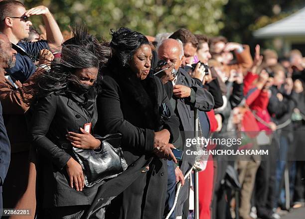 The wind blows on visitors as US President Barack Obama takes off from the South Lawn of the White House aboard Marine One in Washington on November...