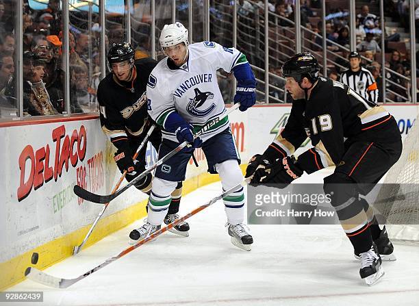Steve Bernier of the Vancouver Canucks has the puck knocked away by Ryan Whitney and Joffrey Lupul of the Anaheim Ducks during their game at the...