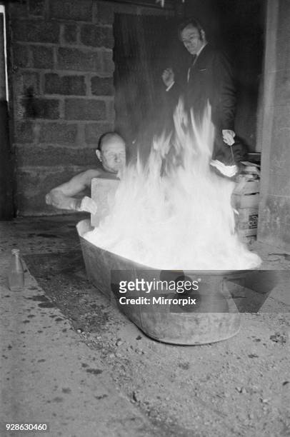 Ron Cunningham pictured in his bath ablaze. Original caption says 'There's nothing like a hot bath on a cold March morning as Ron Cunningham...