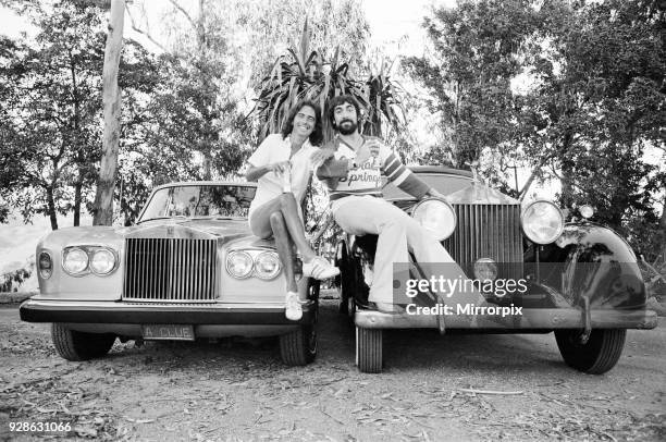 Keith Moon, drummer of The Who rock group and American rock star Alice Cooper pose with their new Rolls Royce cars they bought in spending spree in...