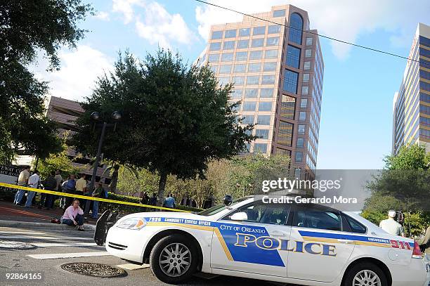 Employees wait outside of the Legions Place office building, where a gunman opened fire wounding several people on November 6, 2009 in Orlando,...