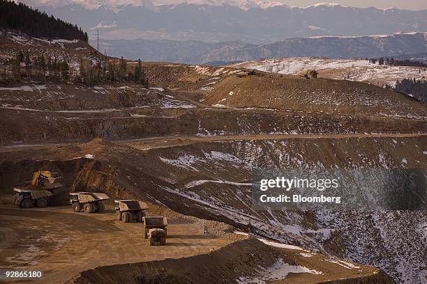 An excavator moves earth into mining trucks at the AngloGold Ashanti Ltd. Cripple Creek & Victor gold mine in Victor/Cripple Creek, Colorado, U.S.,...