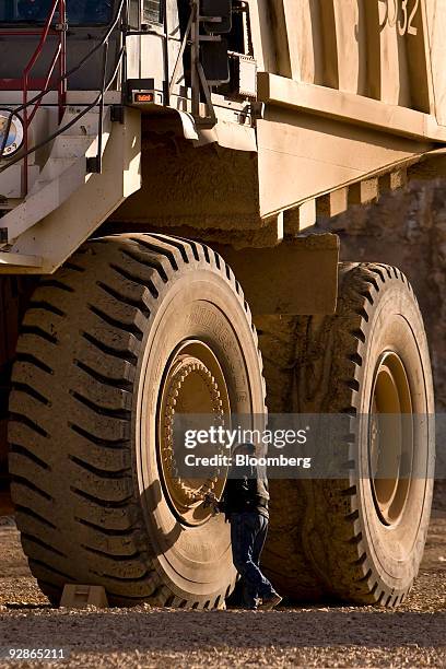 Worker checks the bolts securing a specialty Bridgestone tire on a mining truck at the AngloGold Ashanti Ltd. Cripple Creek & Victor gold mine in...