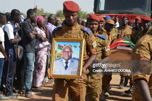 Burkinabe soldiers carry a coffin on March 7 in Ouagadougou, during a commemoration ceremony for eight Burkinabe servicemen killed in twin attacks...
