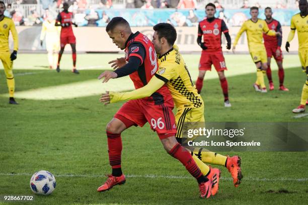 Toronto FC Defender Auro is closely guarded by Columbus Crew SC Defender Milton Valenzuela during the MLS regular season Toronto FC home-opener...