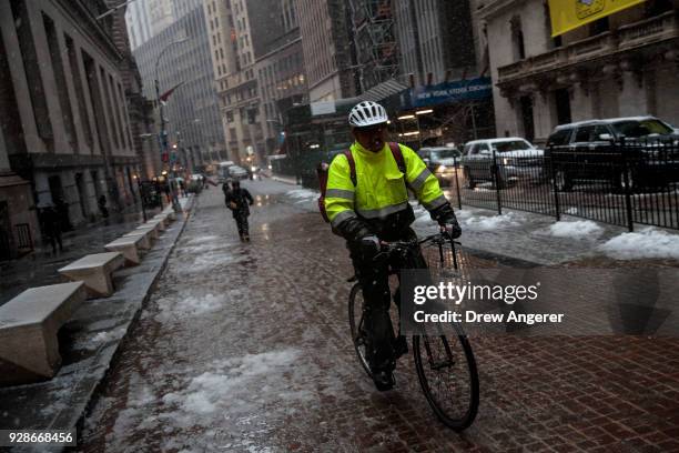 Man rides a bicycle in the Financial District during a snowstorm March 7, 2018 in New York City. This is the second nor'easter to hit the area within...