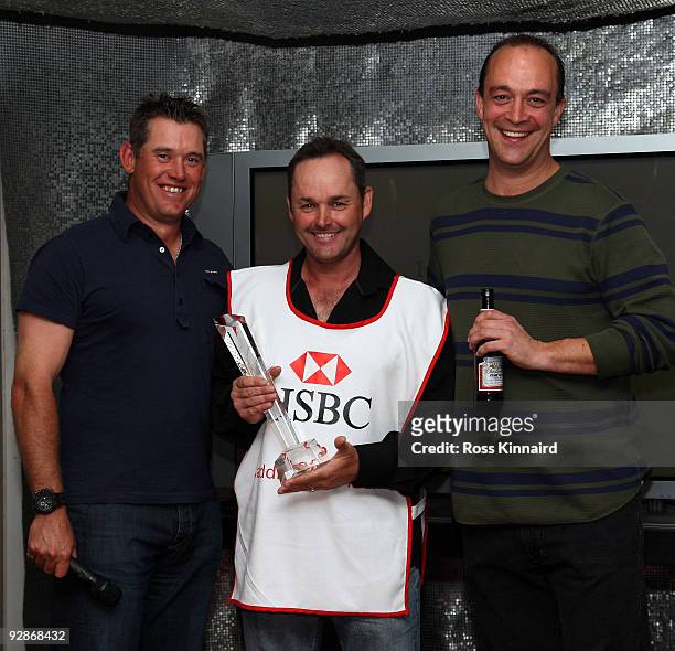Billy Foster is presented with the HSBC Caddie of the Year award by Lee Westwood and Giles Morgan Group Head of Sponsorships for HSBS after the...