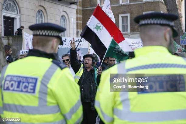 Supporters and Saudi nationals hold flags while welcoming Mohammed bin Salman, Saudi Arabia's crown prince, during a visit with Theresa May, U.K....