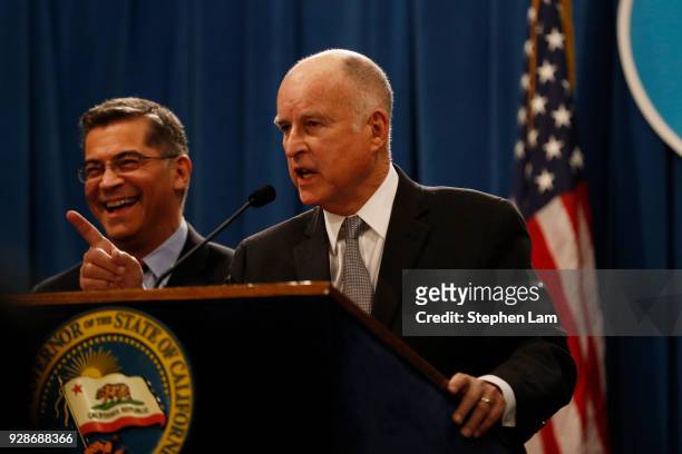 California Governor Jerry Brown gestures as Attorney General Xavier Becerra laughs during a press conference at the California State Capitol on March...