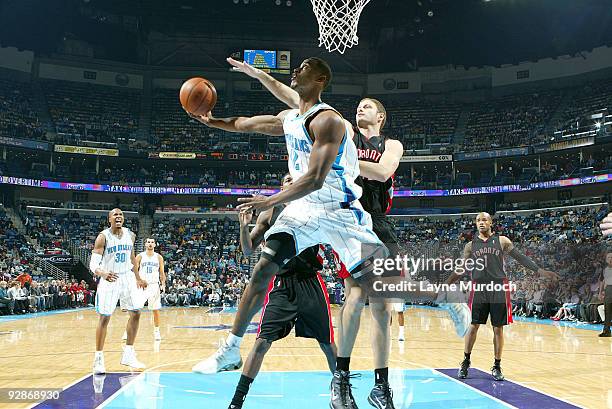 Hilton Armstrong of the New Orleans Hornets shoots over Rasho Nesterovic and Jarrett Jack of the Toronto Raptors on November 6, 2009 at the New...