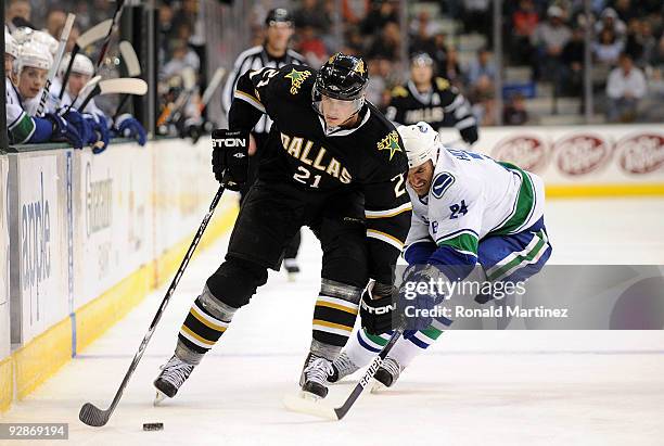 Loui Eriksson of the Dallas Stars skates the puck past Darcy Hordichuk of the Vancouver Canucks at American Airlines Center on November 6, 2009 in...