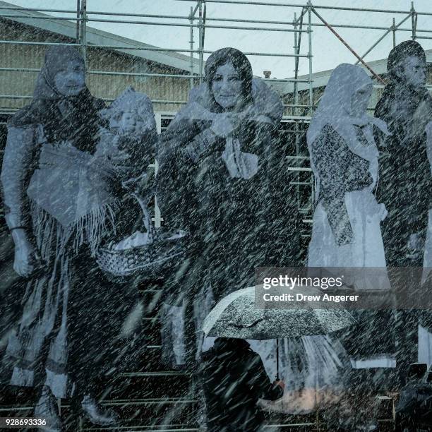 An art installation by French artist JR features refugees on the facade of Pier 94 during a snowstorm, March 7, 2018 in New York City. This is the...