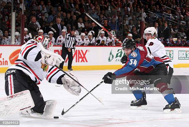 David Jones of the Colorado Avalanche takes a shot against goaltender Antti Niemi and Duncan Keith of the Chicago Blackhawks at the Pepsi Center on...