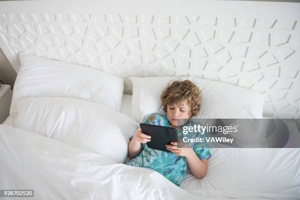 young child sits in bed sick while trying to rest - calcification stock pictures, royalty-free photos & images