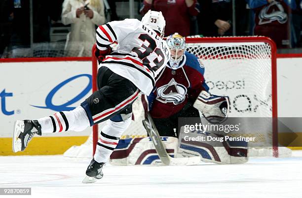 Dustin Byfuglien of the Chicago Blackhawks misses his shot in the eighth round of the overtime shootout against goalie Craig Anderson of the Colorado...