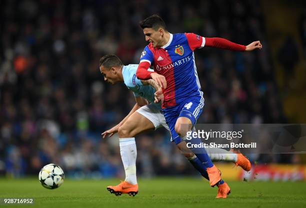 Danilo of Manchester City holds off pressure from Mohamed Elyounoussi of FC Basel during the UEFA Champions League Round of 16 Second Leg match...