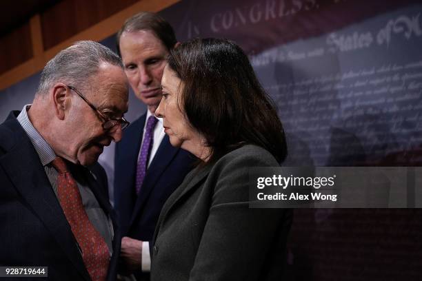 Senate Minority Leader Sen. Chuck Schumer talks to Sen. Maria Cantwell as Sen. Ron Wyden looks on during a news conference at the Capitol March 7,...