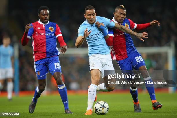 Danilo of Manchester City is tackled by Geoffroy Serey Die and Dimitri Oberlin of FC Basel during the UEFA Champions League Round of 16 Second Leg...