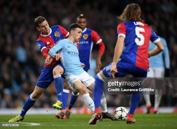 Phil Foden of Manchester City holds off pressure from Fabian Frei of FC Basel during the UEFA Champions League Round of 16 Second Leg match between...
