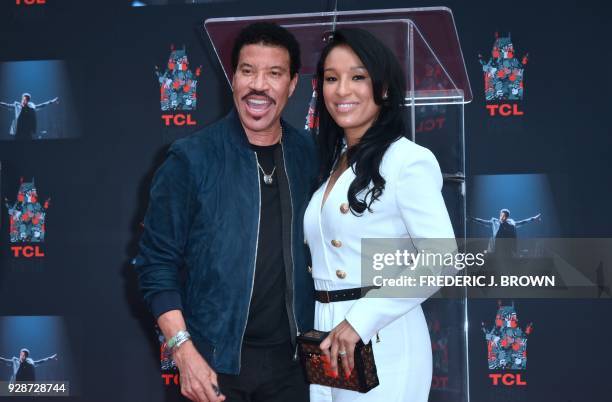 Lionel Ritchie and girlfriend Lisa Parisi at his Hand and Footprints ceremony at the TCL Theater on March 7,2018 in Hollywood, California. / AFP...