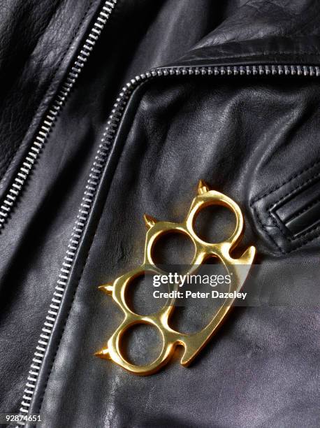 knuckle duster lying on leather jacket. - knuckle duster imagens e fotografias de stock