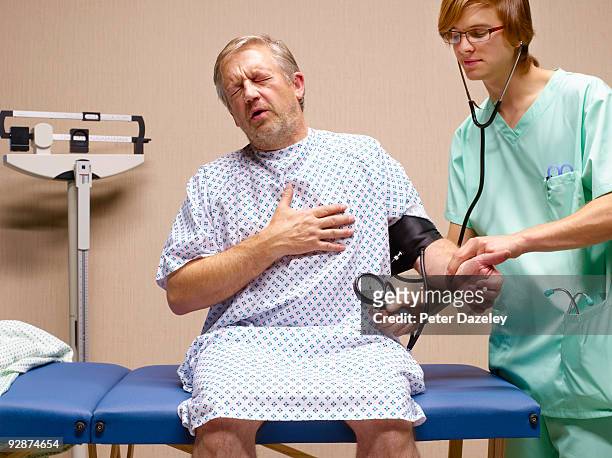 senior man with chest pains having blood pressure  - worried doctor stock pictures, royalty-free photos & images