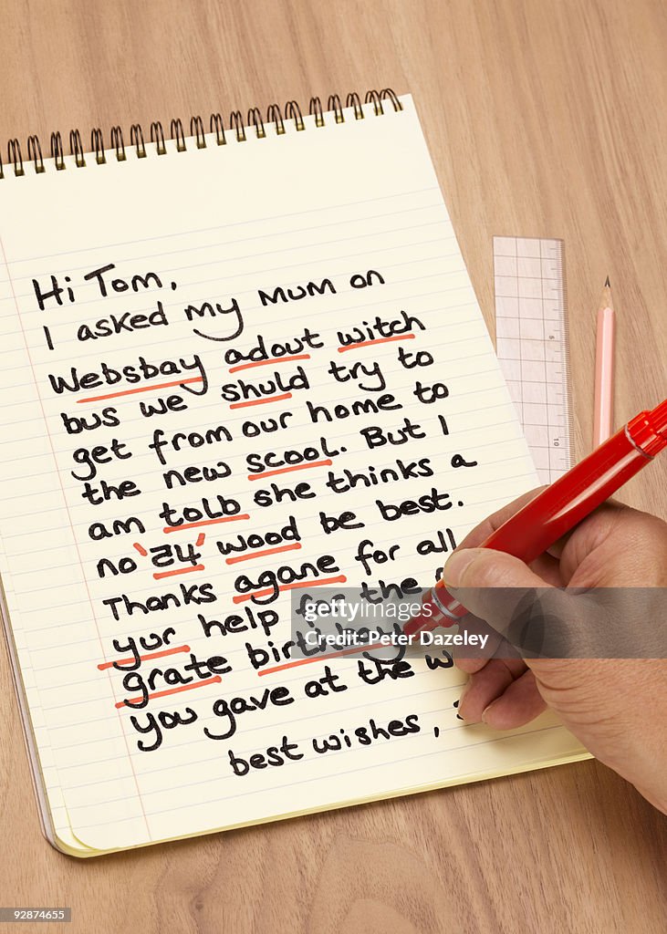 Teacher correcting dyslexic child's letter.