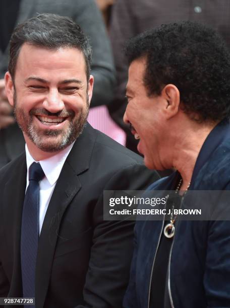 Lionel Ritchie and Jimmy Kimmel at his Hand and Footprints ceremony at the TCL Theater on March 7,2018 in Hollywood, California. / AFP PHOTO /...