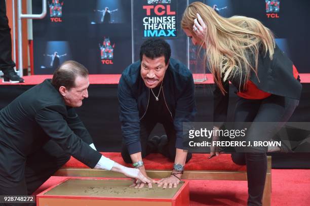 Lionel Ritchie places his hands in the block of cement at his Hand and Footprints ceremony at the TCL Theater on March 7,2018 in Hollywood,...