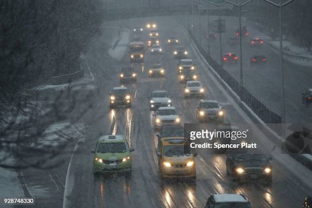 Cars drive through wet snow along a highway on March 7, 2018 in the Brooklyn borough of New York. For the second time in less than a week, a...