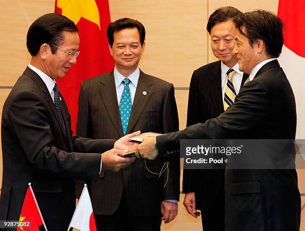 Vietnamese Planning and Investment Minister Vo Hong Phuc, left, shakes hands with Japanese Foreign Minister Katsuya Okada as Vietnamese Prime...