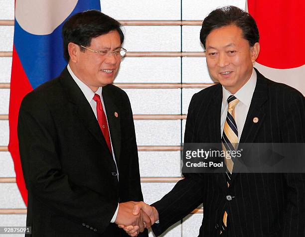 Laotian Prime Minister Bouasone Bouphavanh, left, is welcomed by Japanese Prime Minister Yukio Hatoyama at the Japanese PM's official residence prior...