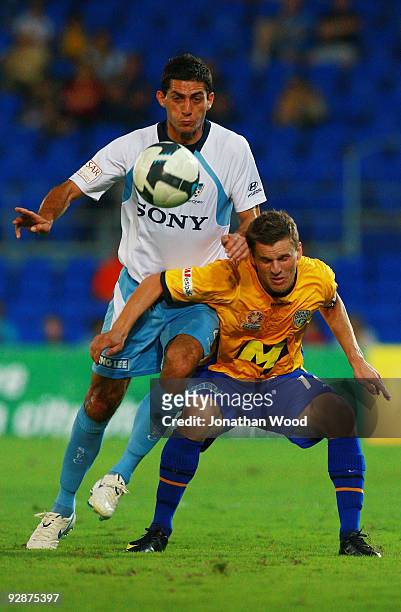 Simon Colosimo of Sydney contests the ball with Jason Culina of the Gold Coast during the round 14 A League match between Gold Coast United and...