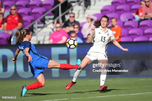 Marion Torrent of France kicks the ball in front of Sara Dbritz of Germany during the SheBelieves Cup soccer match at Orlando City Stadium on March...