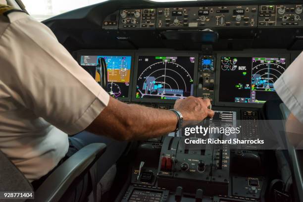 modern commercial jet aircraft cockpit and pilots - pilotar fotografías e imágenes de stock