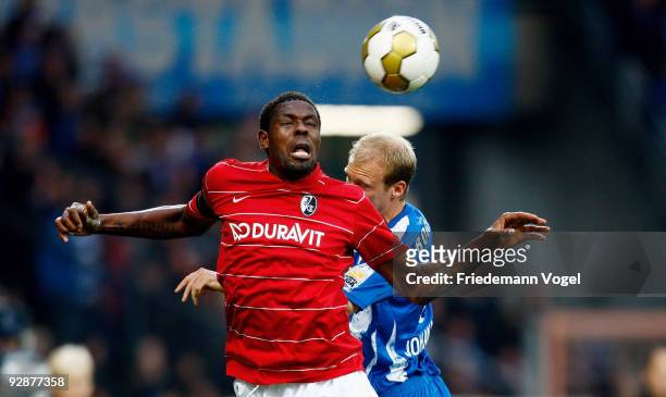 Mohamadou Idrissou of Freiburg vies for a header with Andreas Johansson of Bochum during the Bundesliga match between VfL Bochum and SC Freiburg at...