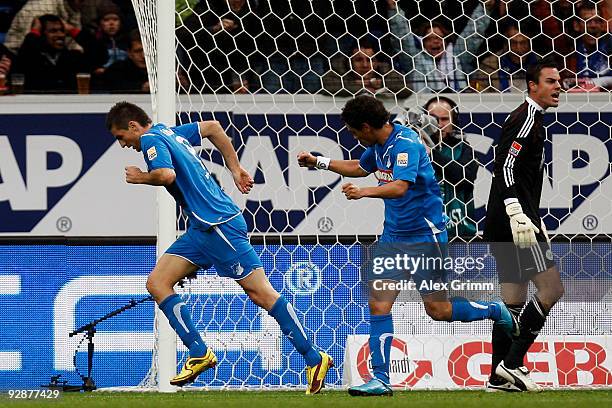 Vedad Ibisevic of Hoffenheim celebrates his team's first goal with team mate Carlos Eduardo as goalkeeper Diego Benaglio of Wolfsburg reacts during...