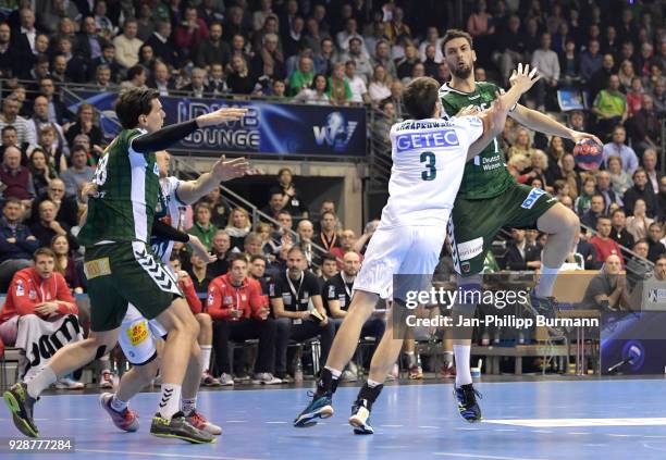 Erik Schmidt of Fuechse Berlin, Piotr Chrapkowski of SC Magdeburg and Marko Kopljar of Fuechse Berlin during the DHB Cup quarterfinal game between...