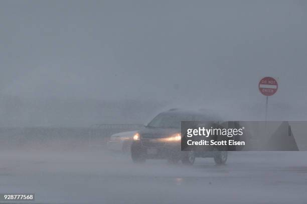 Water from a wave blows over cars parked alongside Quincy Shore Drive as a major nor'easter barrels into the northeastern U.S. On March 7, 2018 in...