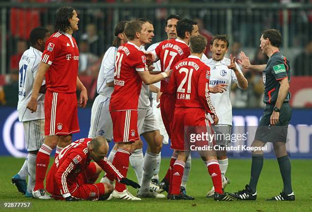 Players of Bayern Muenchen and Schalke argue with referee Florian Meyer after Arjen Robben was fouled during the Bundesliga match between FC Bayern...