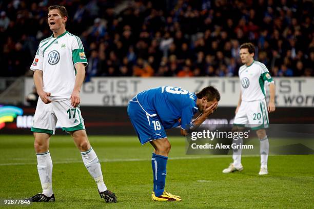 Vedad Ibisevic of Hoffenheim reacts as he stands between Alexander Madlung and Sascha Riether of Wolfsburg during the Bundesliga match between 1899...