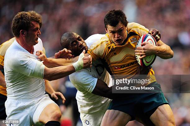 Adam Ashley-Cooper of Australia barges through the attempted tackles from Mark Cueto and Ugo Monye of England to score a try during the Investec...