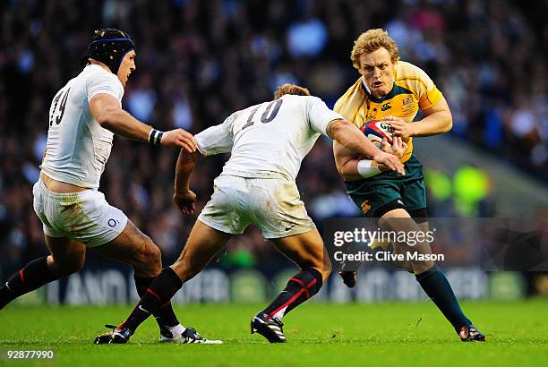 Ryan Cross of Australia is tackled by Jonny Wilkinson of England during the Investec Challenge Series match between England and Australia at...